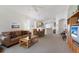 Open-concept living room and dining area with neutral carpet, ceiling fan, and bright natural light at 7432 Birds Eye Ter, Bradenton, FL 34203