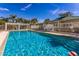 A large swimming pool outside with deck chairs and a cabana with table and chairs for relaxation at 7432 Birds Eye Ter, Bradenton, FL 34203