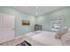 Bedroom with wood floors, ceiling fan, blue blanket on bed, and windows at 815 N East Ave, Sarasota, FL 34237