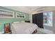 Bedroom with green walls, wood-trimmed windows, and a sliding door to the backyard at 815 N East Ave, Sarasota, FL 34237