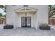 The backyard doors of this home is framed by symmetrical potted plants and a covered structure at 815 N East Ave, Sarasota, FL 34237