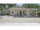 Inviting exterior of a single-story home featuring a cozy front porch and a spacious driveway with a carport at 815 N East Ave, Sarasota, FL 34237