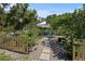 Charming backyard garden with a quaint fence, stone pathway, and shaded seating area at 1111 Harefield Cir, Sun City Center, FL 33573
