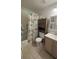 Cozy bathroom with tiled shower and floors, ample cabinet space, and modern fixtures at 1111 Harefield Cir, Sun City Center, FL 33573