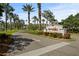 Elegant community entrance sign, Kings Point, with lush landscaping and mature palm trees at 1111 Harefield Cir, Sun City Center, FL 33573