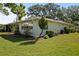 This house features lush landscaping, mature trees, and a serene, inviting outdoor space at 1111 Harefield Cir, Sun City Center, FL 33573