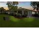 Charming single-story home with well-manicured lawn and inviting, covered front porch at dusk at 1111 Harefield Cir, Sun City Center, FL 33573