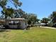 Home exterior featuring a well-manicured lawn and mature trees in a quiet neighborhood at 1111 Harefield Cir, Sun City Center, FL 33573