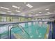 Large indoor pool with stairs, lane markers, and plenty of natural light at 1111 Harefield Cir, Sun City Center, FL 33573