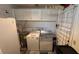 Functional laundry room with washer, dryer, water heater, storage cabinets and folding area at 1111 Harefield Cir, Sun City Center, FL 33573