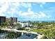 Beautiful aerial view of a waterfront condo building with lush landscaping and ocean views at 1115 Gulf Of Mexico Dr # 304, Longboat Key, FL 34228