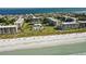 Stunning aerial view of beachfront condos and pristine sandy beach with turquoise water and complex pool at 1115 Gulf Of Mexico Dr # 304, Longboat Key, FL 34228