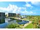 Scenic aerial view of condos, a pond with fountain, and lush tropical landscaping by the ocean at 1115 Gulf Of Mexico Dr # 304, Longboat Key, FL 34228