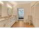 Bathroom with double sinks, granite counters and wood floors leading to bedroom at 1115 Gulf Of Mexico Dr # 304, Longboat Key, FL 34228