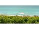 Picture perfect view of a secluded beach with lounge chairs and an umbrella at 1115 Gulf Of Mexico Dr # 304, Longboat Key, FL 34228