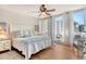 Bright main bedroom with a cozy bed, ceiling fan, and floor-to-ceiling windows with curtains at 1115 Gulf Of Mexico Dr # 304, Longboat Key, FL 34228