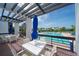 Relaxing pool deck area with blue umbrellas and white seating overlooking the pool at 1115 Gulf Of Mexico Dr # 304, Longboat Key, FL 34228