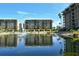 Beautiful water view of complex buildings and pond with fountain, and palm tree landscaping at 1115 Gulf Of Mexico Dr # 304, Longboat Key, FL 34228