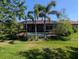 Landscaped backyard with lush lawn, pool, mature trees and plants, and outdoor living space at 119 Maraviya Blvd, Nokomis, FL 34275