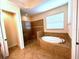 Bathroom featuring a soaking tub, a glass shower, neutral tile, and natural light at 119 Maraviya Blvd, Nokomis, FL 34275