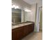 Bathroom with granite countertops, double sinks, dark cabinetry, and neutral tile flooring at 119 Maraviya Blvd, Nokomis, FL 34275