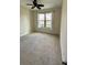 Bright bedroom with a ceiling fan, a large window with natural light, and neutral carpet at 119 Maraviya Blvd, Nokomis, FL 34275