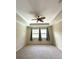 Bright bedroom featuring a ceiling fan, neutral walls and carpet, and a pair of windows with curtains at 119 Maraviya Blvd, Nokomis, FL 34275