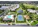 Aerial view highlighting community's desirable features, including the community pool, tennis courts, clubhouse, and scenic landscaping at 12327 Halfmoon Lake Ter, Bradenton, FL 34211