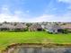 Rear view of homes backing to large green space with mature landscape and pond at 12327 Halfmoon Lake Ter, Bradenton, FL 34211