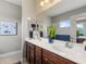Bright bathroom features a double vanity with a white countertop and wooden cabinets at 12327 Halfmoon Lake Ter, Bradenton, FL 34211