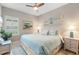 Cozy bedroom features a queen bed with coastal decor and a ceiling fan at 12327 Halfmoon Lake Ter, Bradenton, FL 34211