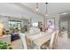 Open dining room features a light wood table, contemporary pendant lighting, and a view of the living area at 12327 Halfmoon Lake Ter, Bradenton, FL 34211