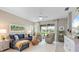Comfortable living room features a blue sectional sofa, recliner chairs, and large windows with backyard views at 12327 Halfmoon Lake Ter, Bradenton, FL 34211