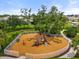 Community playground with slides and climbing structures surrounded by a mulch base and white picket fence at 12327 Halfmoon Lake Ter, Bradenton, FL 34211