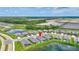 Aerial view of a residential community with serene lake and green expanses, showcasing a peaceful neighborhood at 12743 Tahitian Pearl Cir, Parrish, FL 34219