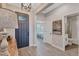 Warm foyer with modern light fixtures, leading to a bedroom and bathroom, complemented by wood-look tile flooring at 12743 Tahitian Pearl Cir, Parrish, FL 34219