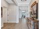 Inviting hallway featuring wood-look tile flooring leading to a living room with serene views of a lake at 12743 Tahitian Pearl Cir, Parrish, FL 34219