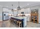 Stylish kitchen with white cabinets, contrasting island with bar stools, and modern stainless steel appliances at 12743 Tahitian Pearl Cir, Parrish, FL 34219
