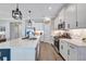 Modern kitchen with white cabinets, stainless steel appliances, quartz countertops, and hardwood floors at 12743 Tahitian Pearl Cir, Parrish, FL 34219