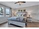 Comfortable main bedroom with wood-look tile flooring, nature-inspired artwork, and peaceful waterfront view at 12743 Tahitian Pearl Cir, Parrish, FL 34219