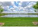 Scenic view of a serene pond reflecting a clear sky, surrounded by well-maintained green spaces and residential homes at 12743 Tahitian Pearl Cir, Parrish, FL 34219