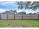 Fenced backyard with green grass, partially covered with tree shade at 1451 Fawnwood Cir, Sarasota, FL 34232