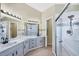 Bathroom featuring double sinks, modern fixtures, granite countertops, and a glass-enclosed shower at 1451 Fawnwood Cir, Sarasota, FL 34232