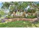 Community entrance sign framed by lush greenery and a brick border at 1451 Fawnwood Cir, Sarasota, FL 34232