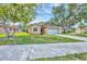 Inviting single-story home featuring a lush green lawn, mature trees, and an attached two-car garage at 1451 Fawnwood Cir, Sarasota, FL 34232