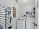 Functional laundry room with modern washer and dryer units and storage at 1451 Fawnwood Cir, Sarasota, FL 34232