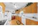 Well-lit kitchen featuring wood cabinets, white appliances, and tile countertops at 17 Braden Castle Dr, Bradenton, FL 34208