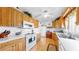 Functional kitchen featuring wood cabinets, white appliances, and tile countertops at 17 Braden Castle Dr, Bradenton, FL 34208