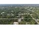 Aerial view looking down shows house under construction situated amongst a densely wooded residential community at 17461 Dudley Ave, Port Charlotte, FL 33954