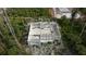 Aerial view of unfinished block home, showing open floorplan in a wooded, partially developed area at 17461 Dudley Ave, Port Charlotte, FL 33954